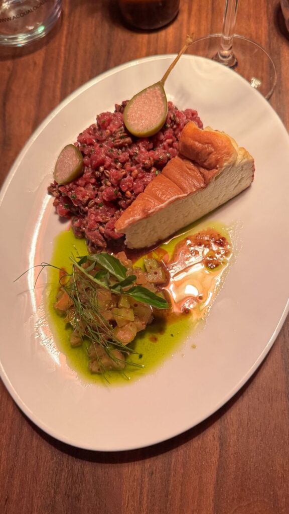 Prato de carne crua servida em apresentação individual, com temperos distribuídos na superfície.