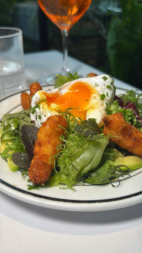 Uma das saladas mais emblemáticas do Happening Costanera, com langostinos crocantes, folhas frescas e um ovo perfeito que transforma o prato em uma experiência sensorial.