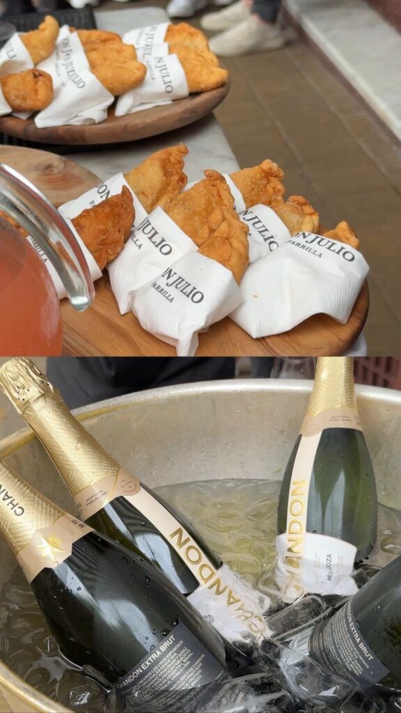 Empanadas quentinhas e Chandon sendo servidos na fila de espera.