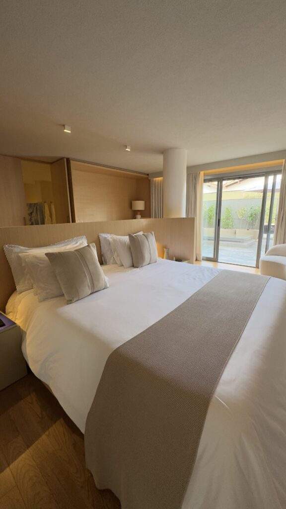 Quarto da Suíte 01 do Íz Hotel Conceito, em Goiânia, com cama Super King, decoração contemporânea e varanda privativa com hidromassagem ao fundo.